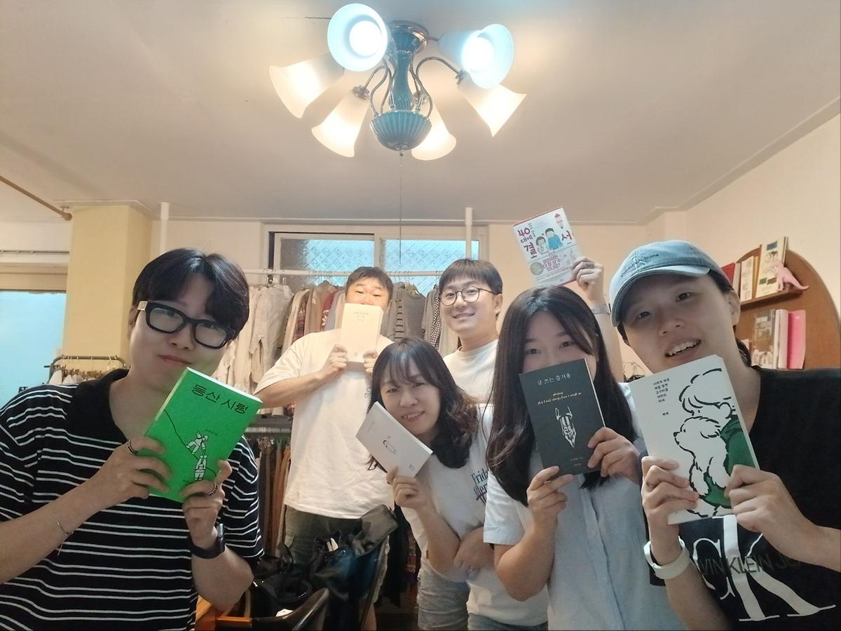 북극 서점 내 각자 선호하는 책 디자인을 선정하여 함께 찍은 사진 사진